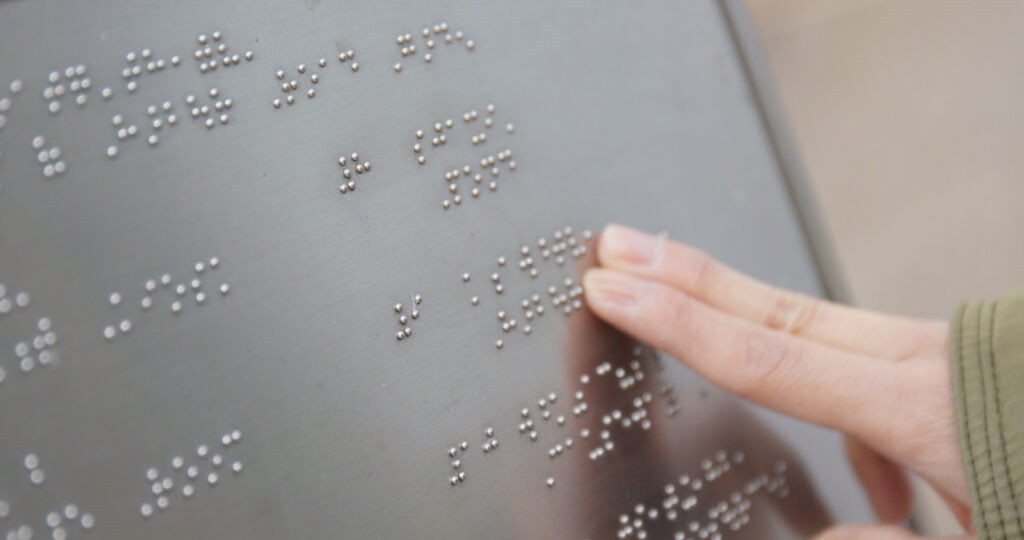 Ręka dotykająca napisów Braille, WCAG dla początkujących wcag 2.2 wcag 2.1